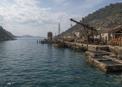 Puerto romano de Vicus Spacorum, con barcos amarrados, grúa de madera, ánforas, depósitos de salazón y actividad portuaria junto a la ría.