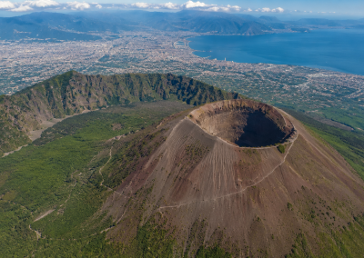 Vista aérea del Vesubio con el Gran Cono, el Monte Somma, el cráter volcánico y la bahía de Nápoles al fondo.